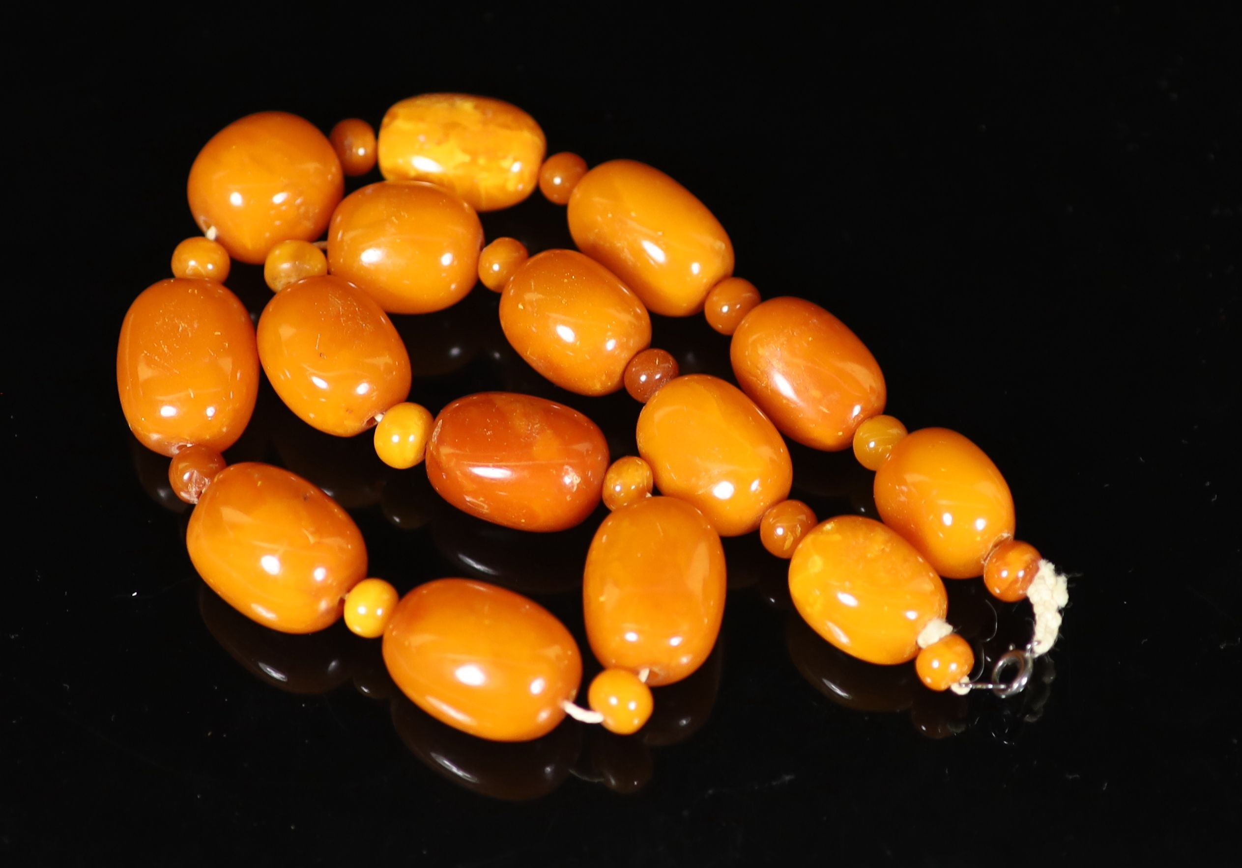 A single stand barrel shaped amber bead necklace, with amber bead spacers